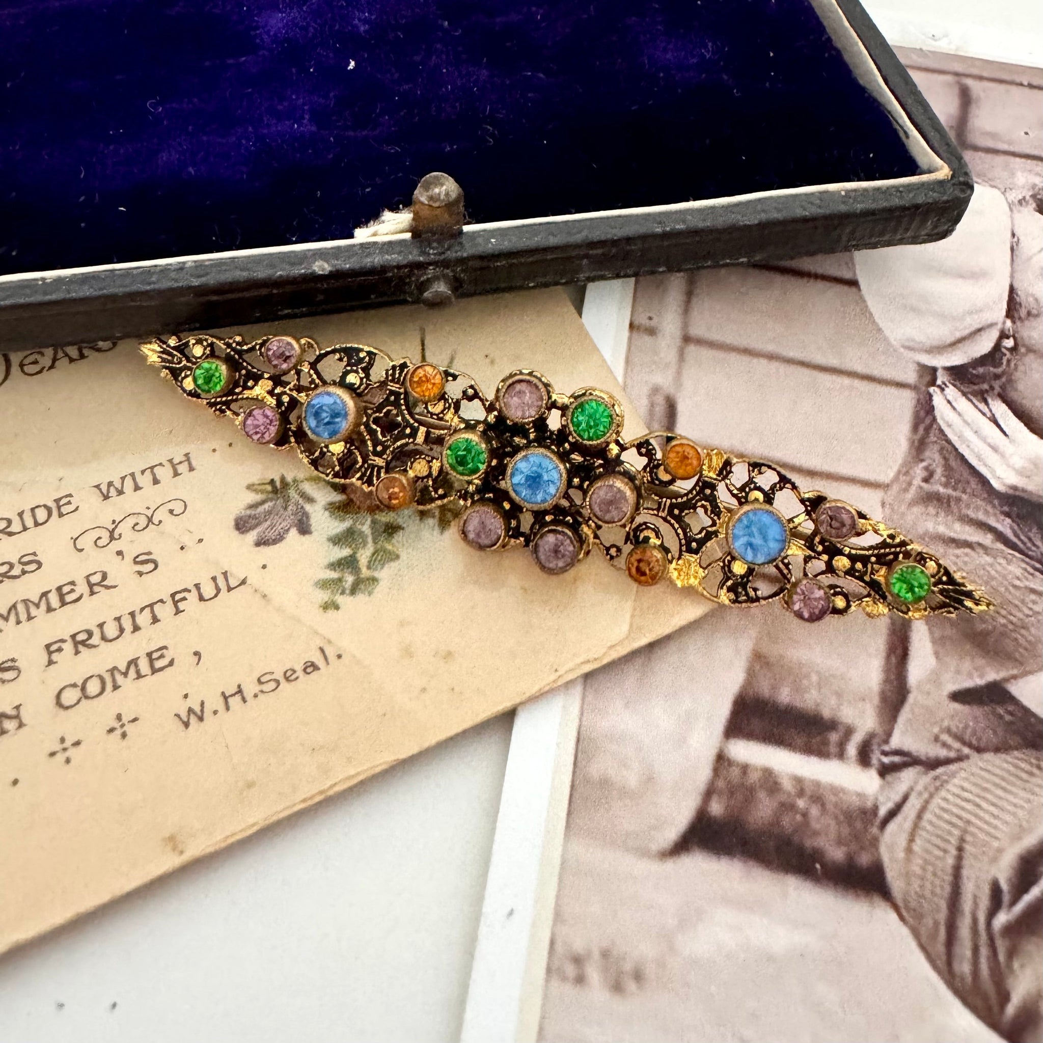 Vonk jewellery vintage crystal brooch on vintage postcards. There is a vintage jewellery box in the corner.