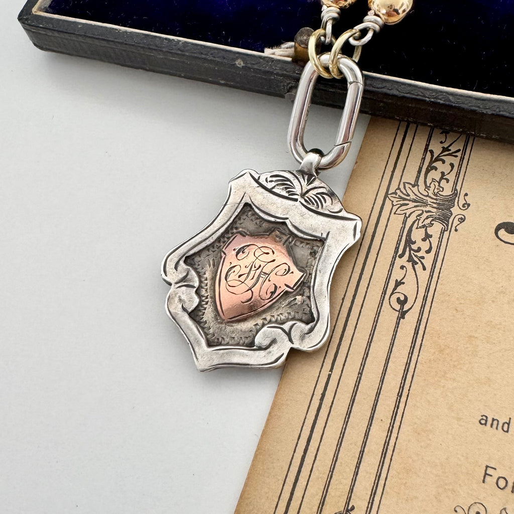 1919 sterling silver watch fob and pearl necklace on a vintage jewellery box and old photo