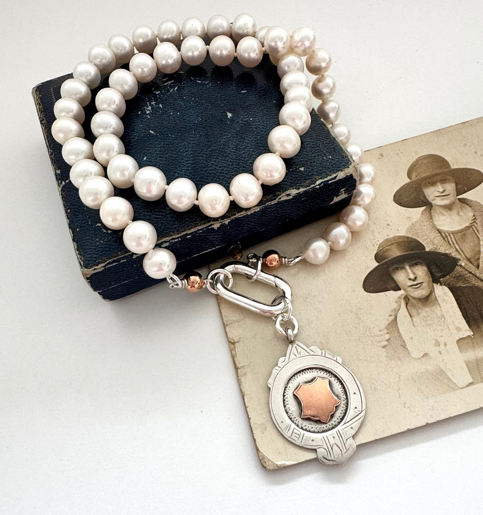 1932 silver and rose gold watch fob pearl necklace on an old jewellery box and photograph of women in the 1920's