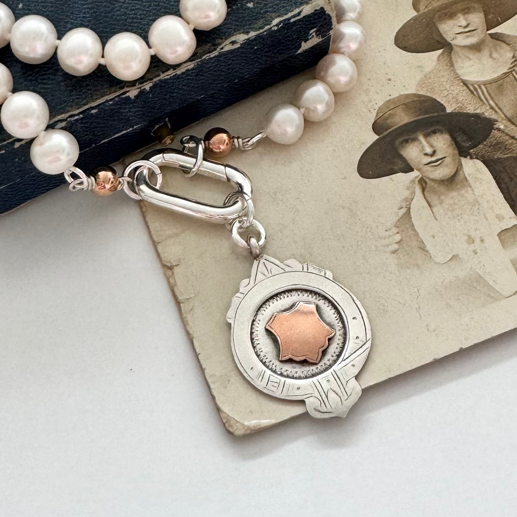 1932 silver and rose gold watch fob pearl necklace on an old jewellery box and photograph of women in the 1920's