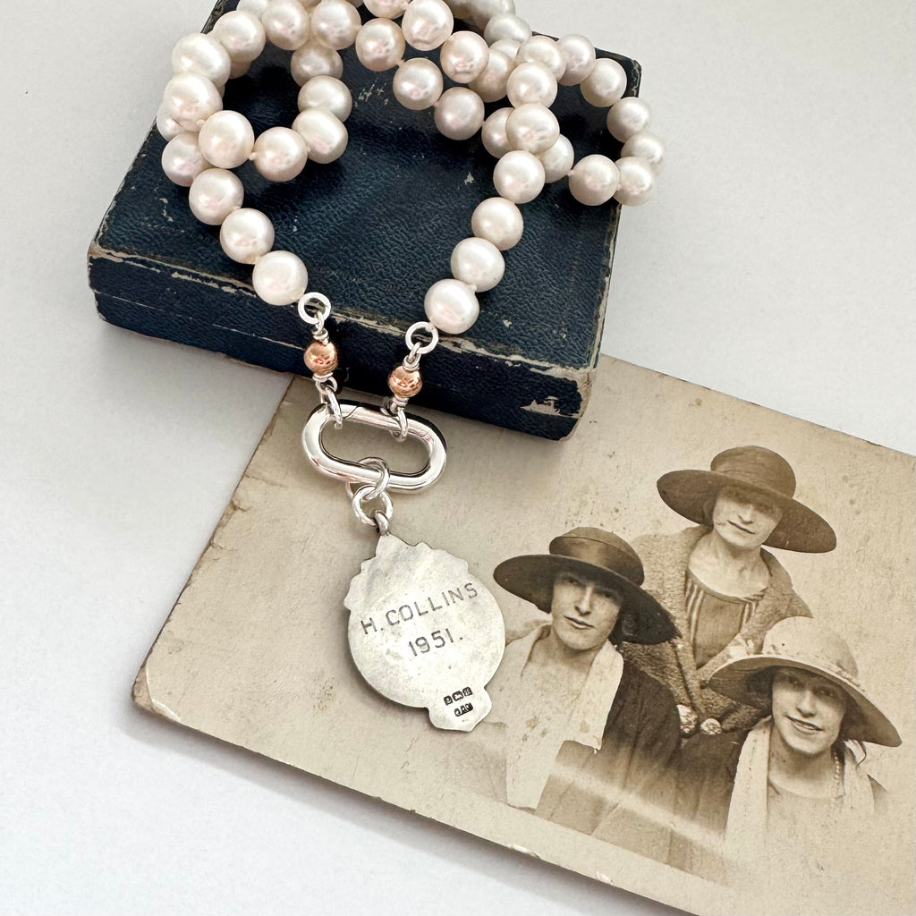 1932 silver and rose gold watch fob pearl necklace on an old jewellery box and photograph of women in the 1920's