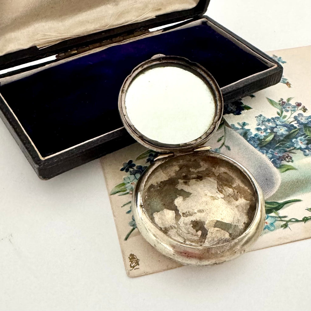 Vintage powder compact with mirror on a floral card