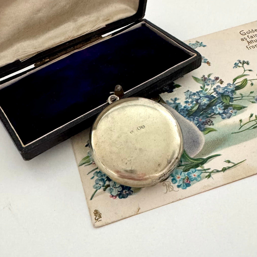 Vintage silver pocket watch in an open case on a floral card