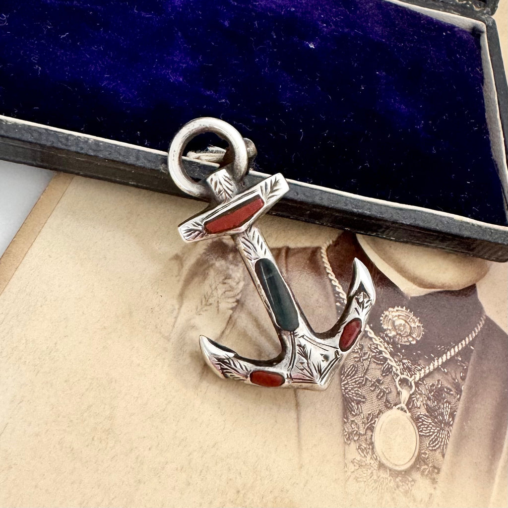 Antique sterling silver and agate anchor brooch on an antique photo