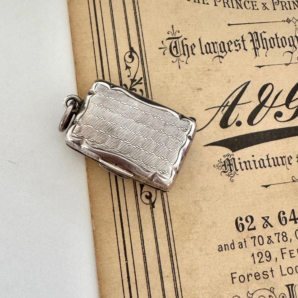 Antique 1864 sterling silver vinaigrette on an antique advertising material for a photography studio