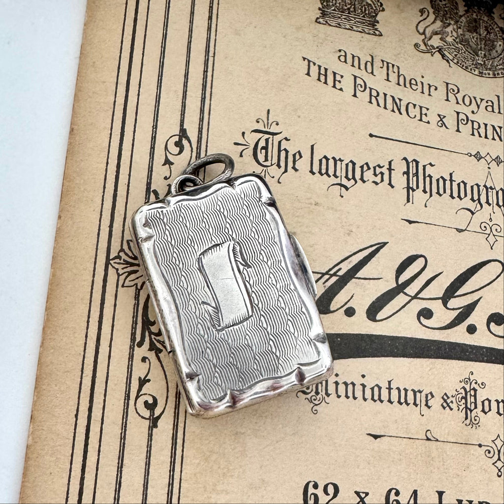 Antique 1864 sterling silver vinaigrette on an antique advertising material for a photography studio