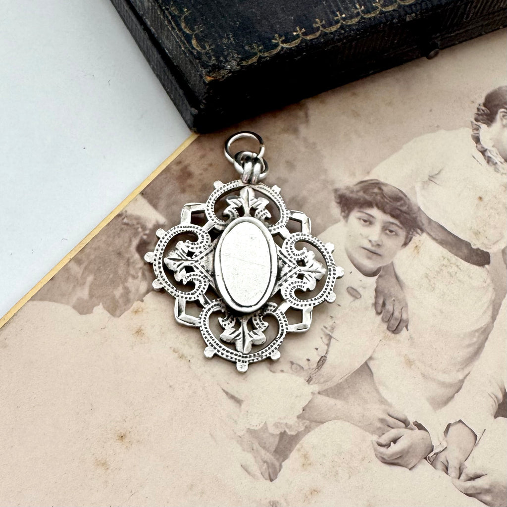 Antique silver watch fob pendant on an old photograph