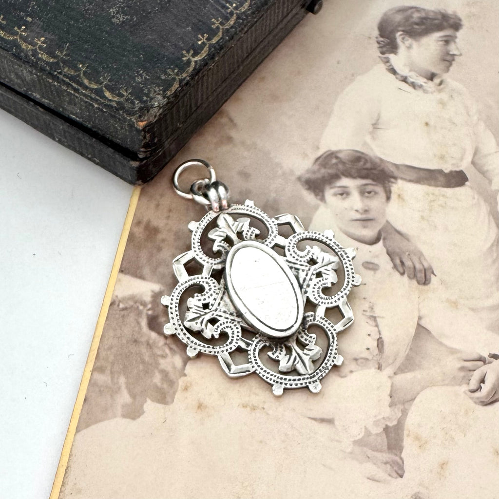 Antique silver watch fob pendant on an old photograph