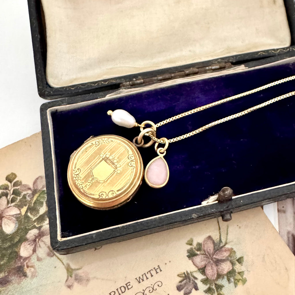 Vonk Jewellery 9ct gold back and front Edwardian locket with pearl and pink opal charms on vintage postcards and on a vintage jewellery box