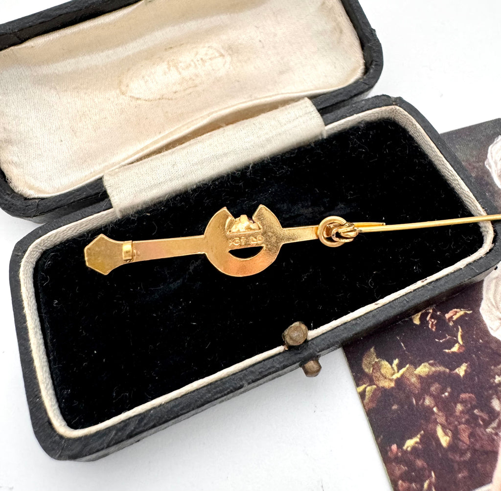Gold brooch in an open jewelry box on a white background