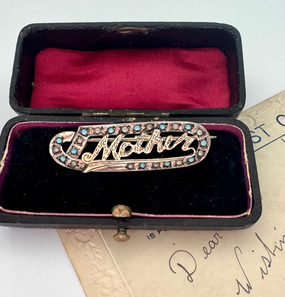 Edwardian 9ct gold silver lined 'Mother' brooch with turquoise and seed pearls in a black case with red interior on an old letter background
