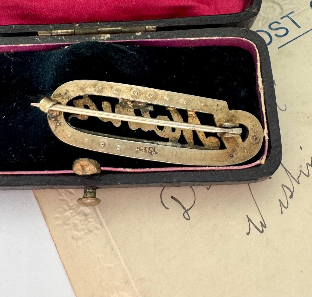 Back of Edwardian 9ct gold silver lined 'Mother' brooch with turquoise and seed pearls in a black case with red interior on an old letter background
