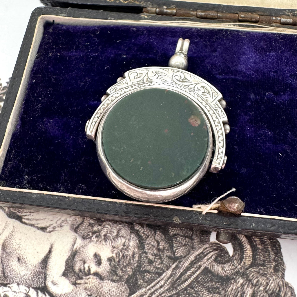 Antique 1896 Chester hallmarked carnelian and bloodstone spinning fob on a jewellery box.