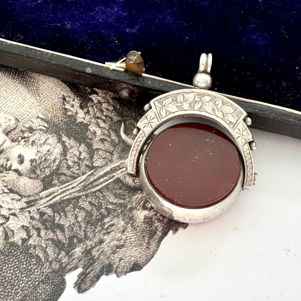 Antique 1896 Chester hallmarked carnelian and bloodstone spinning fob on a jewellery box.