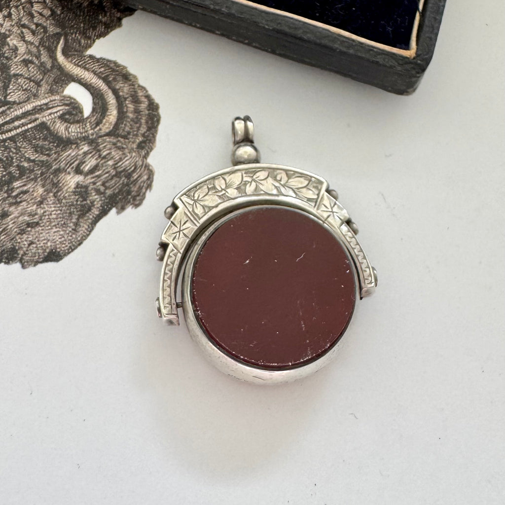 Antique 1896 Chester hallmarked carnelian and bloodstone spinning fob on a jewellery box.
