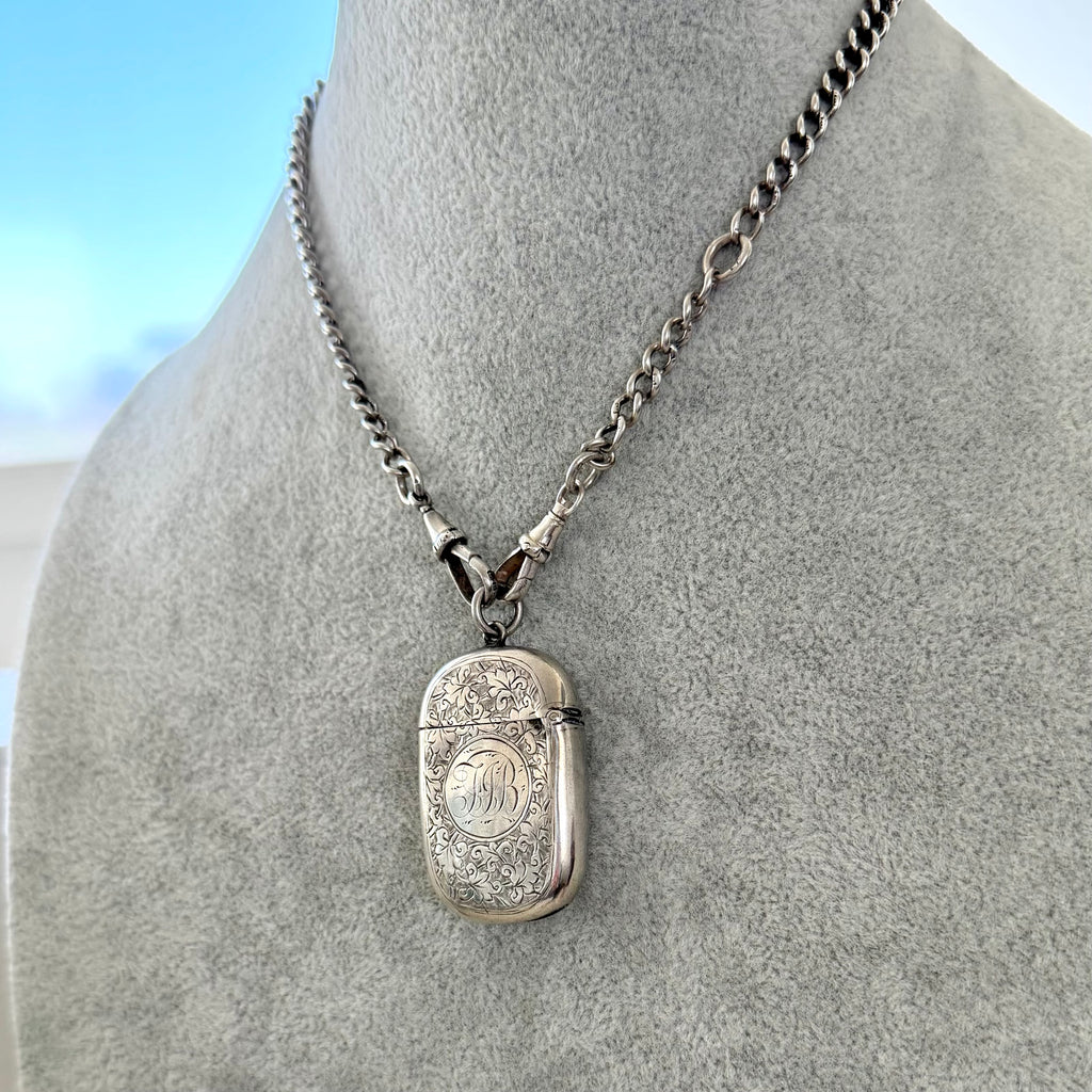 Antique silver watch chain necklace with a sterling silver antique vesta case pendant on a mannequin bust.