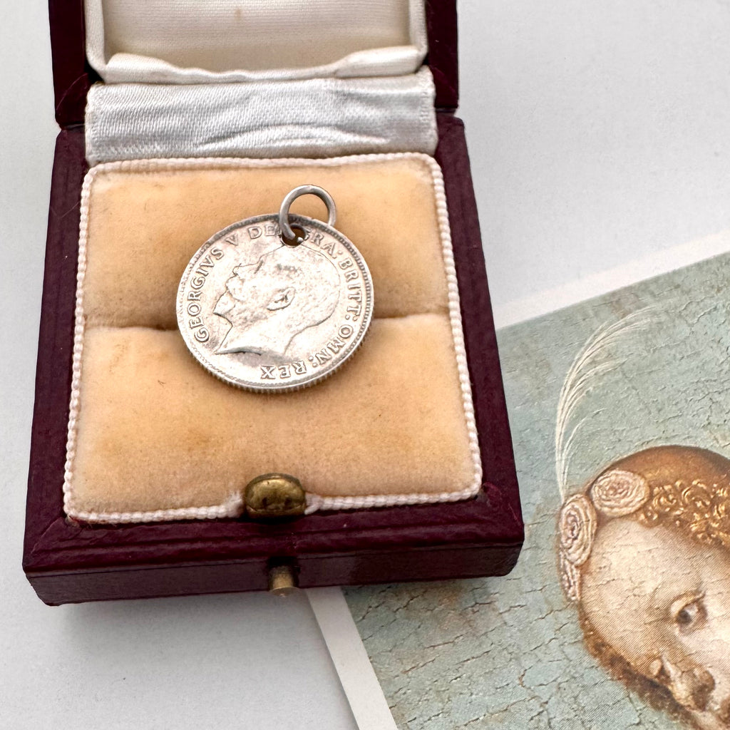 Antique silver British sixpence with 'Albert' engraved in a decorative box on an image of an angel.