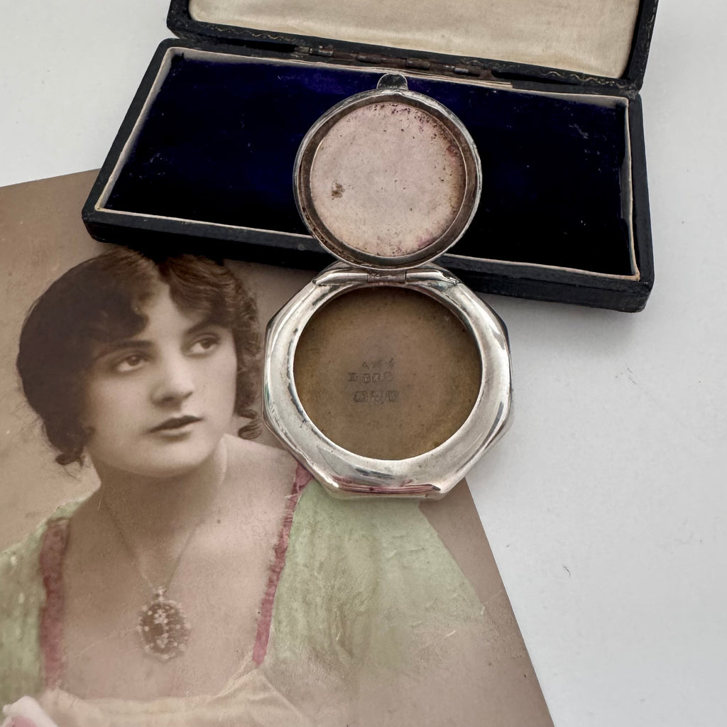 Antique silver compact with a portrait of a woman on a white background