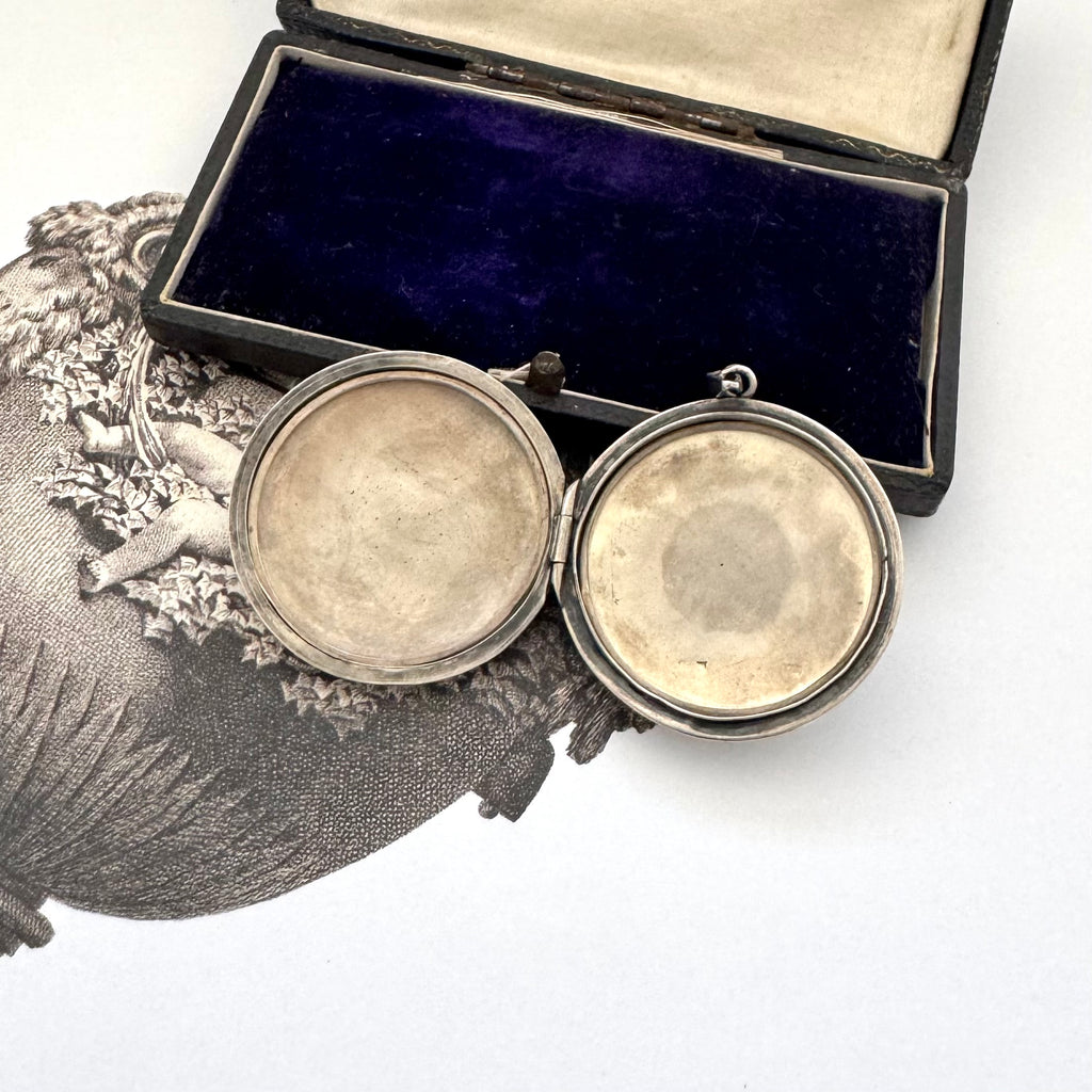 Silver locket with open face on a white background