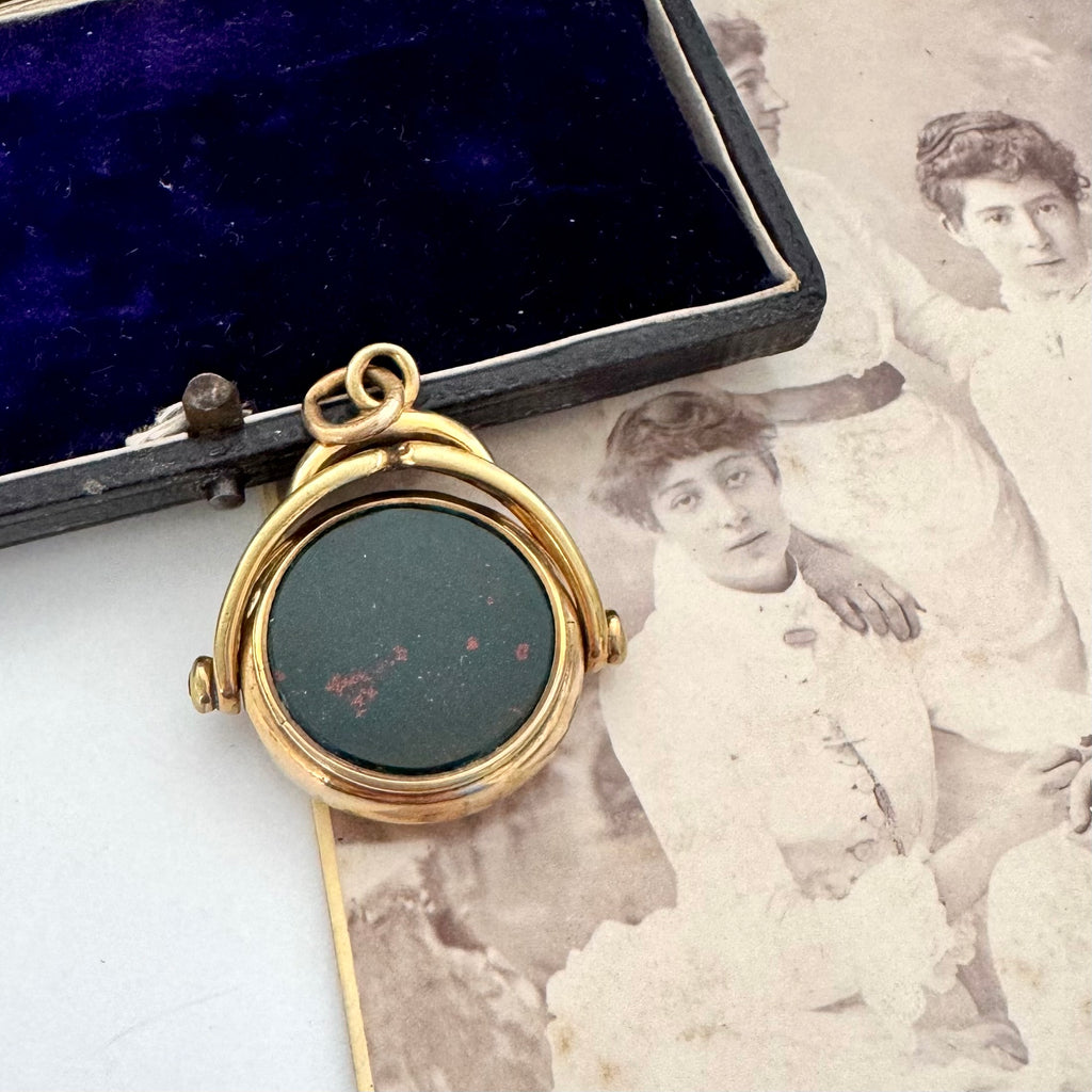 Rolled gold antique spinning fob with a dark stone on an old photograph