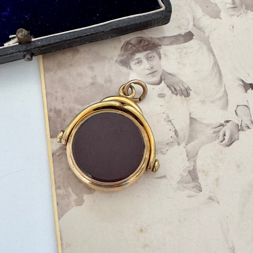 Rolled gold antique spinning fob with a dark stone on an old photograph