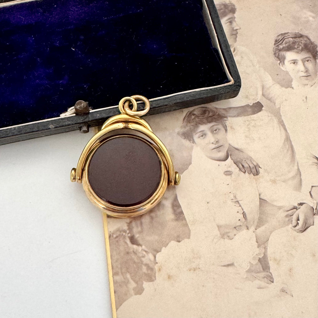 Rolled gold antique spinning fob with a dark stone on an old photograph
