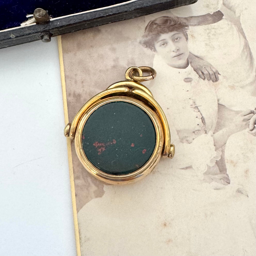 Rolled gold antique spinning fob with a dark stone on an old photograph