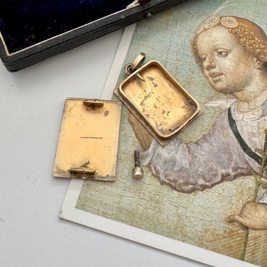 Open antique early vintage silver reliquary locket or pendant with an engraving of Byzantine Madonna and Child on a picture of an angel