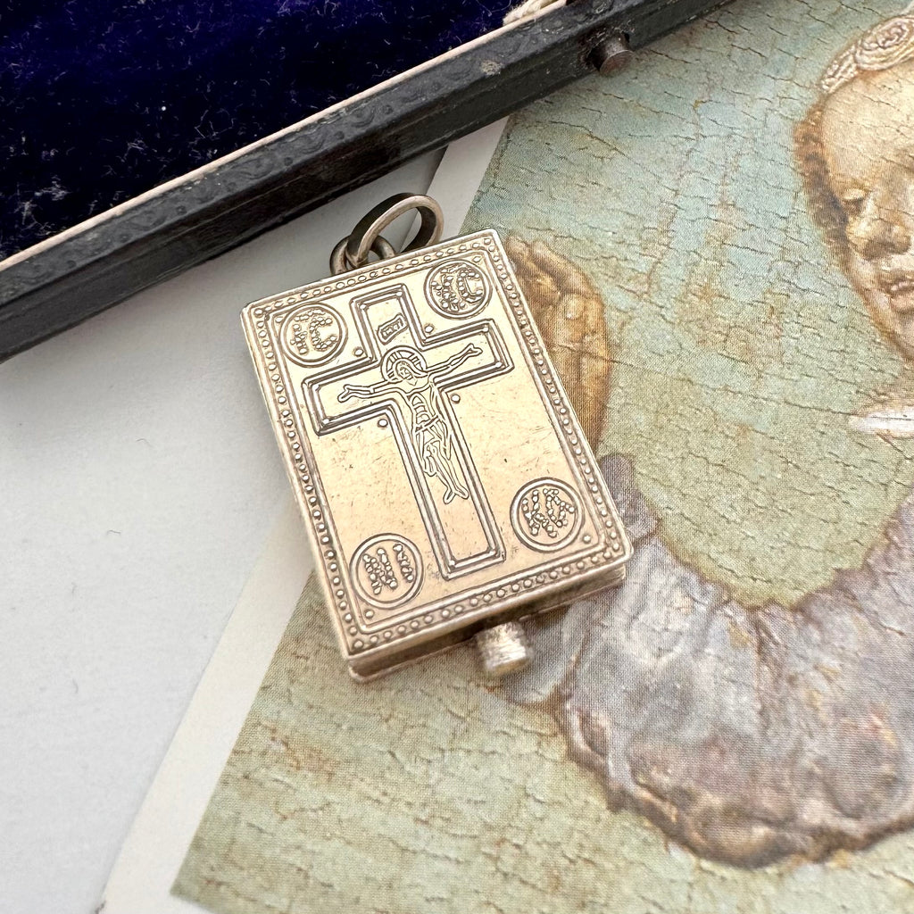 Antique early vintage silver reliquary locket or pendant with an engraving of the crucifixion on a picture of an angel
