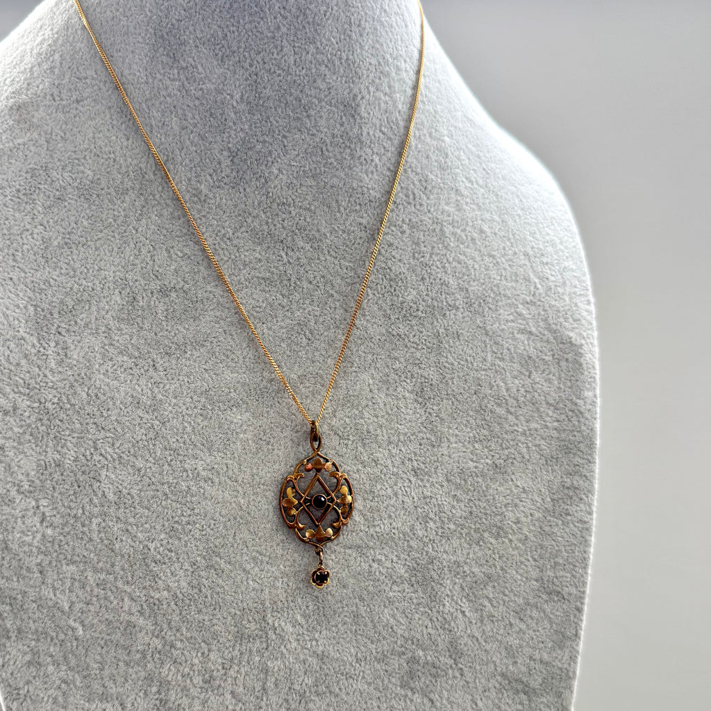 Antique Edwardian art nouveau lavalier pendant necklace displayed on a gray fabric jewelry bust.