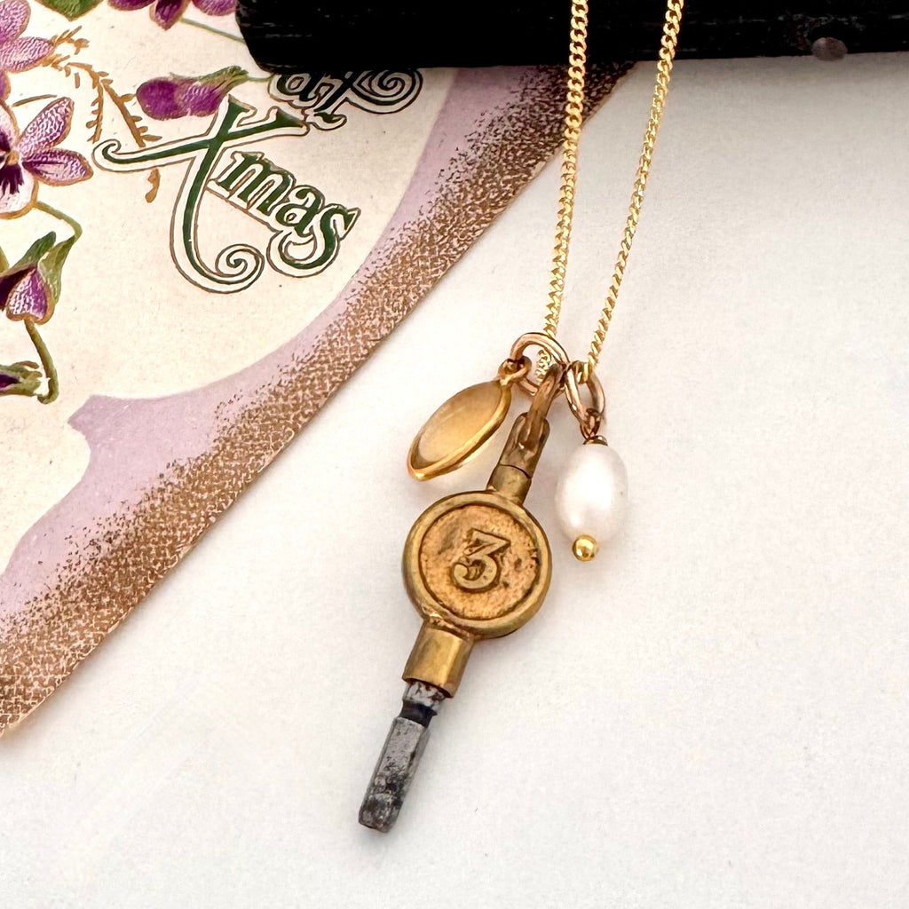 Vonk Jewellery antique pocket watch charm necklace on a white background and with a vintage Christmas postcard