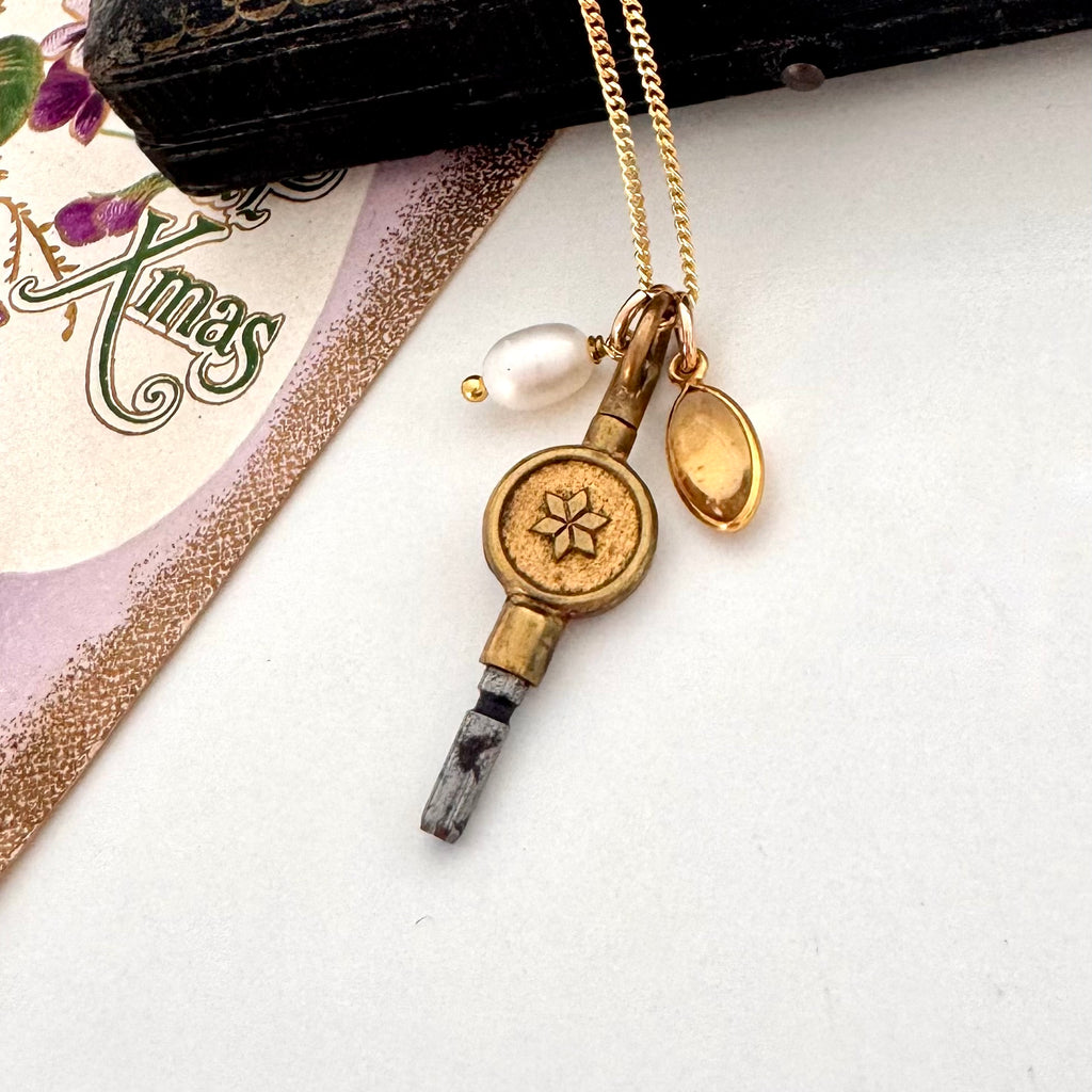 Vonk Jewellery antique pocket watch charm necklace on a white background and with a vintage Christmas postcard