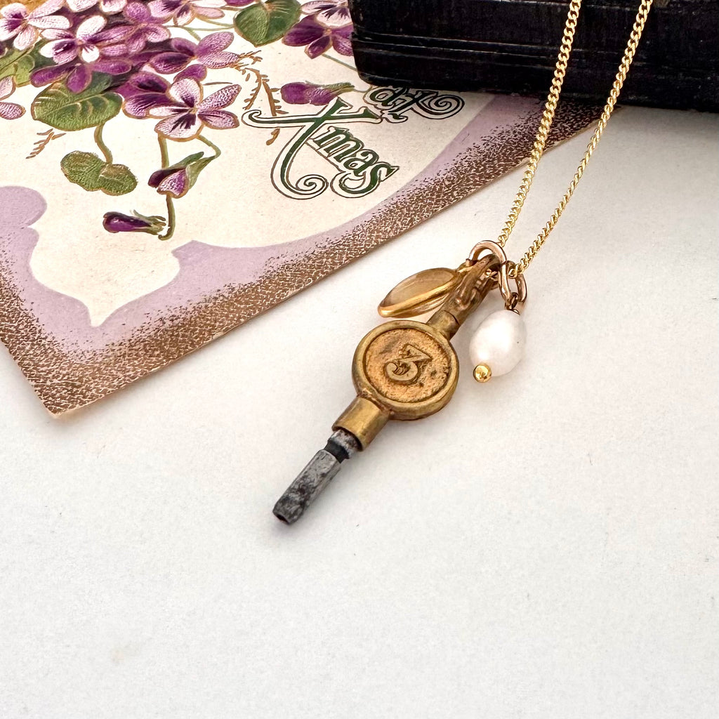 Vonk Jewellery antique pocket watch charm necklace on a white background and with a vintage Christmas postcard