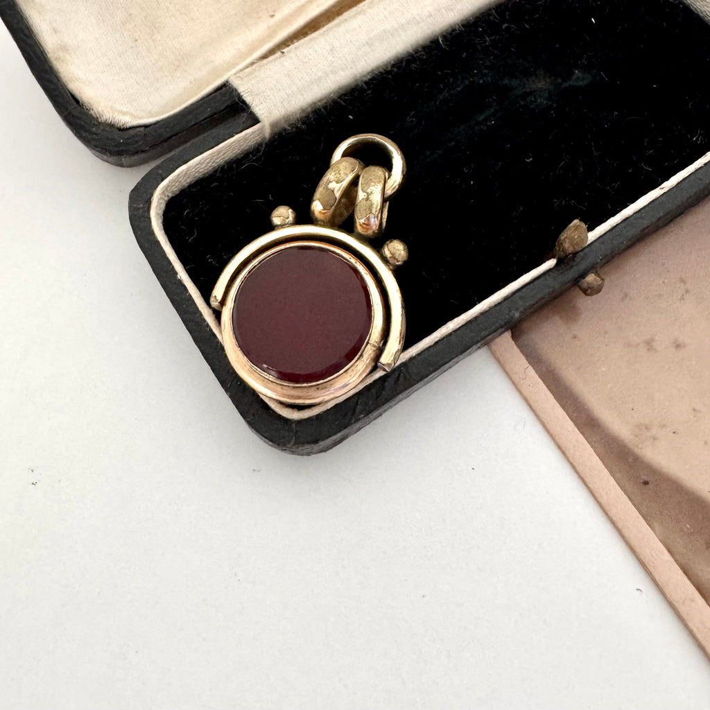 Antique carnelian and bloodstone rolled gold spinning fob on an old jewellery box