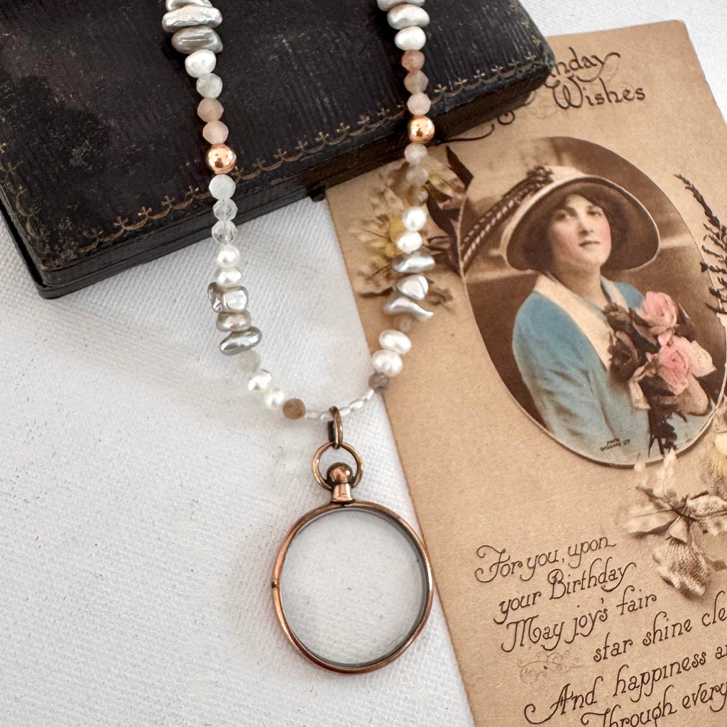 Antique photo locket and crystal and pearl necklace on a vintage card