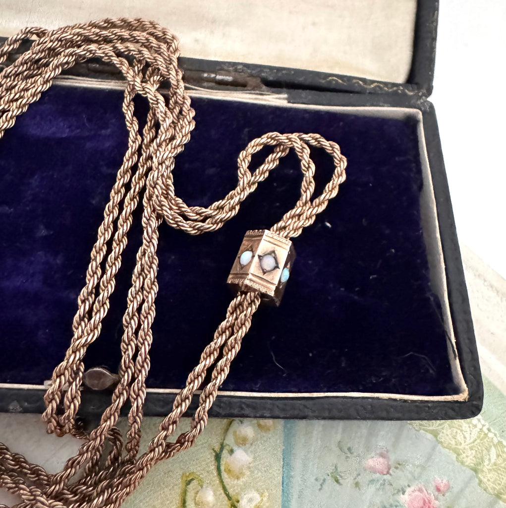 Antique A.H.B & C rolled rose gold guard chain with opal slider on an old postcard.