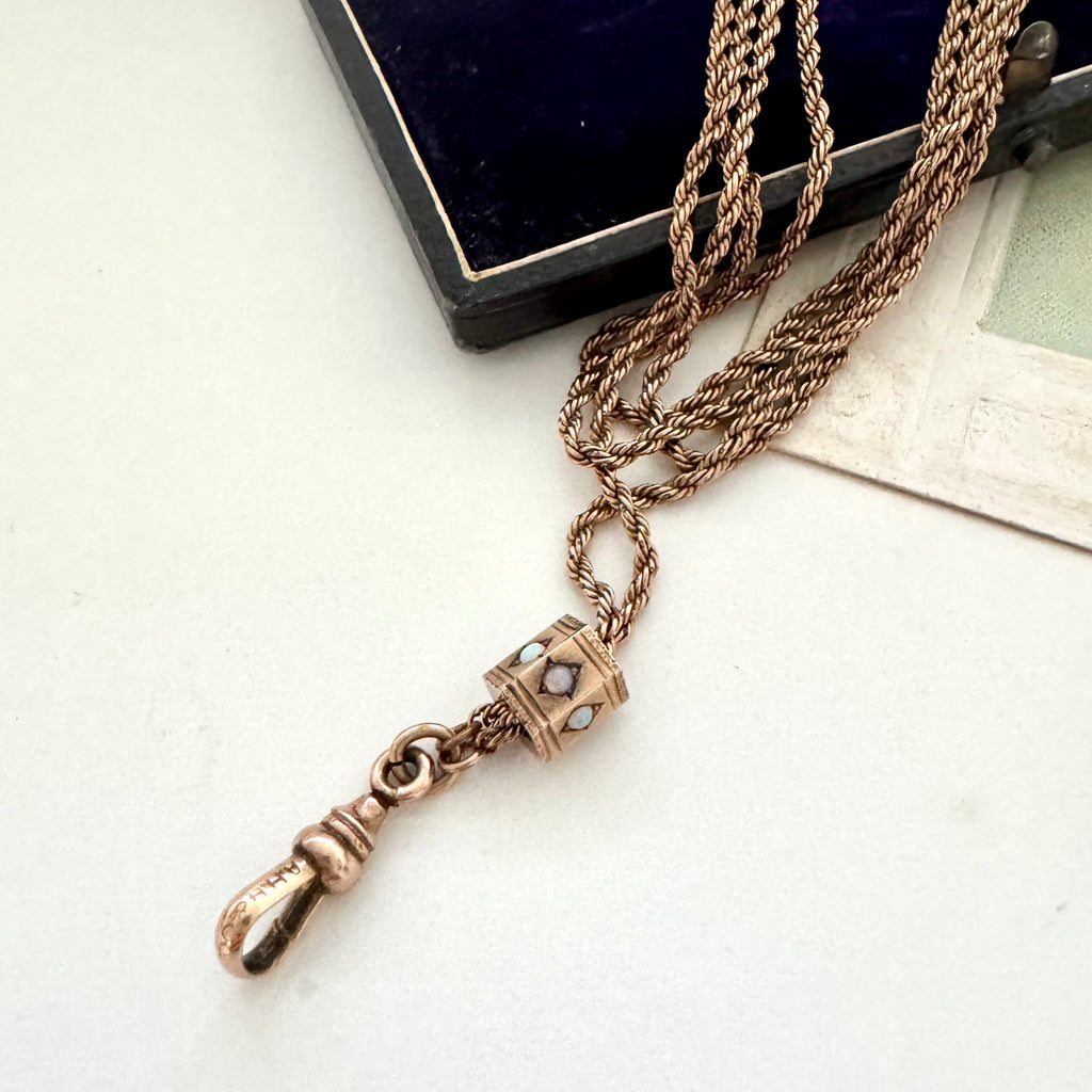 Antique A.H.B & C rolled rose gold guard chain with opal slider on an old postcard.