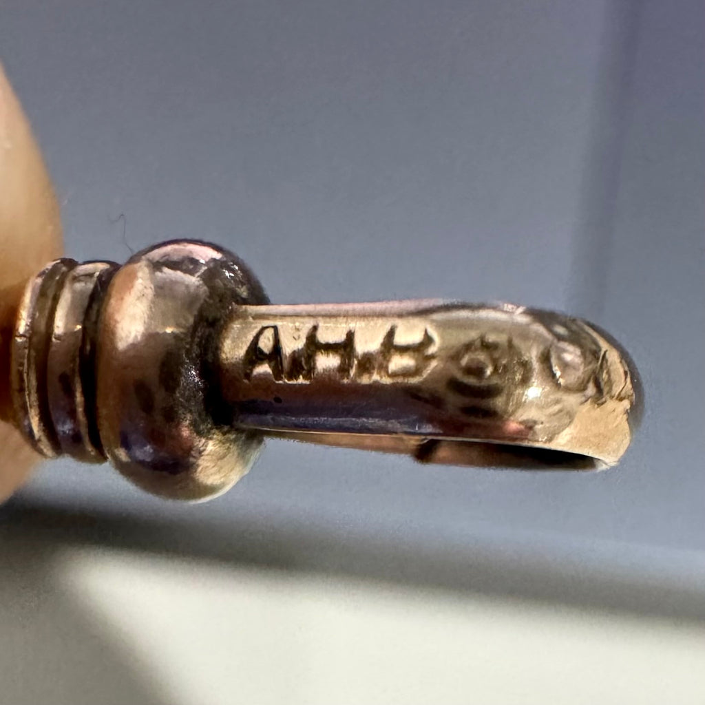 Close-up of A.H.B & Co clip on an antique guard chain on a neutral background