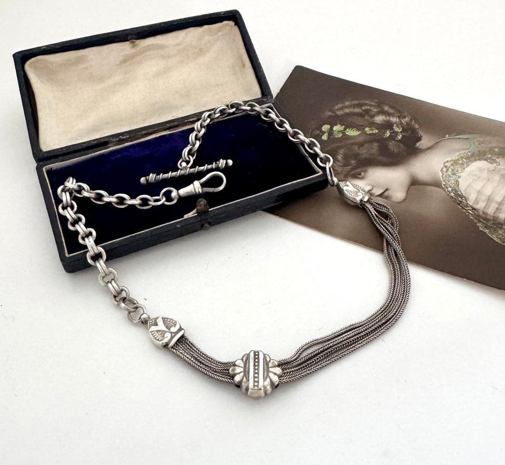 Antique albertina chain on a white background and with an old postcard and box