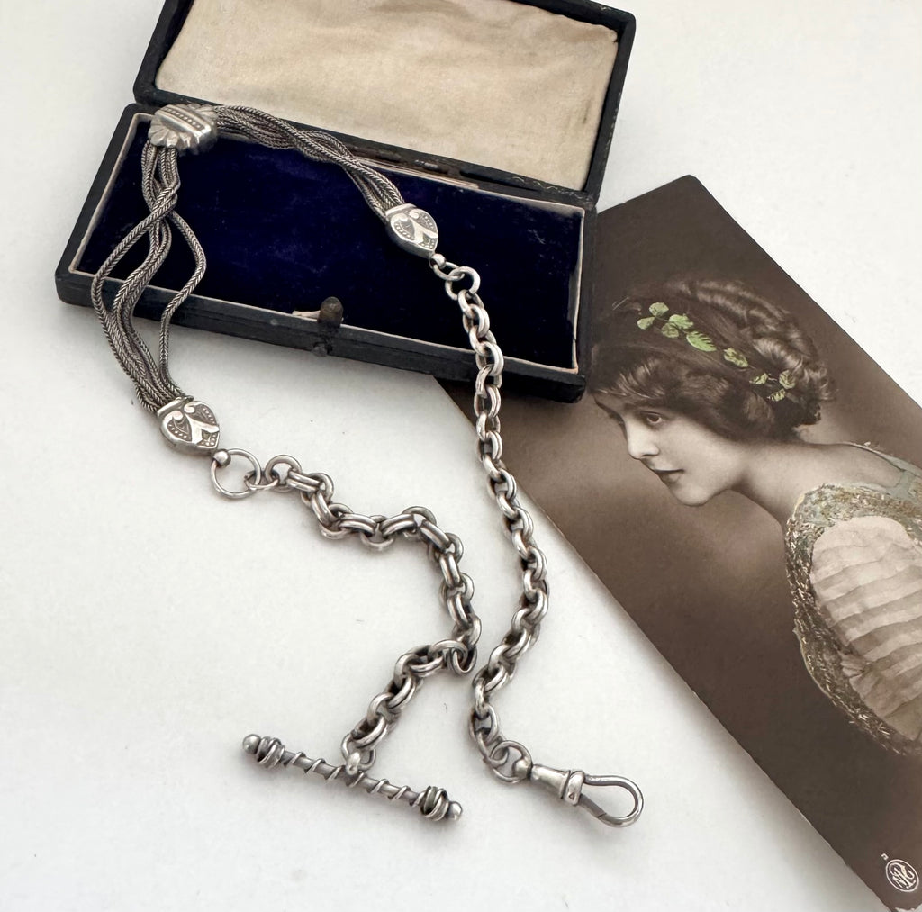 Antique albertina chain on a white background and with an old postcard and box