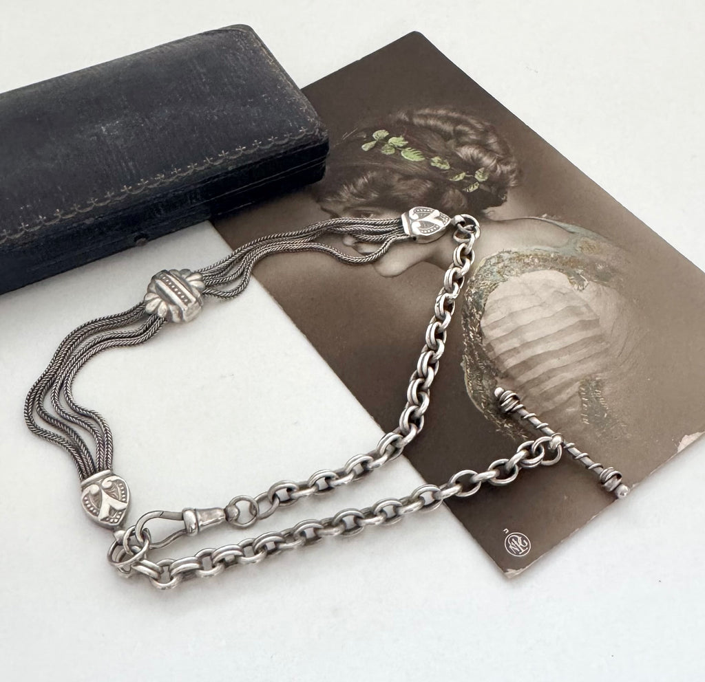 Antique albertina chain on a white background and with an old postcard and box