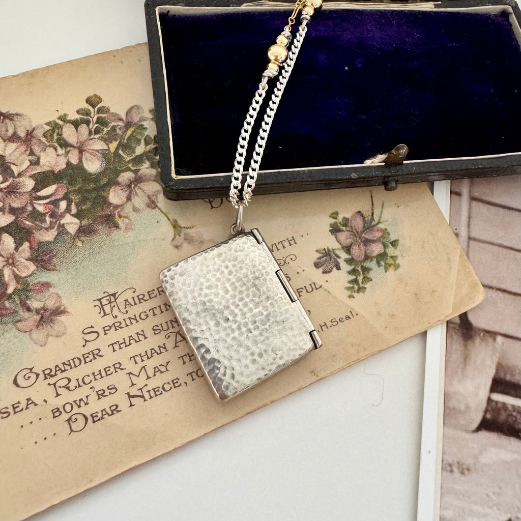 Vonk Jewellery antique 1909 arts and crafts stamp case necklace on a vintage postcard with purple flowers and a vintage jewellery box
