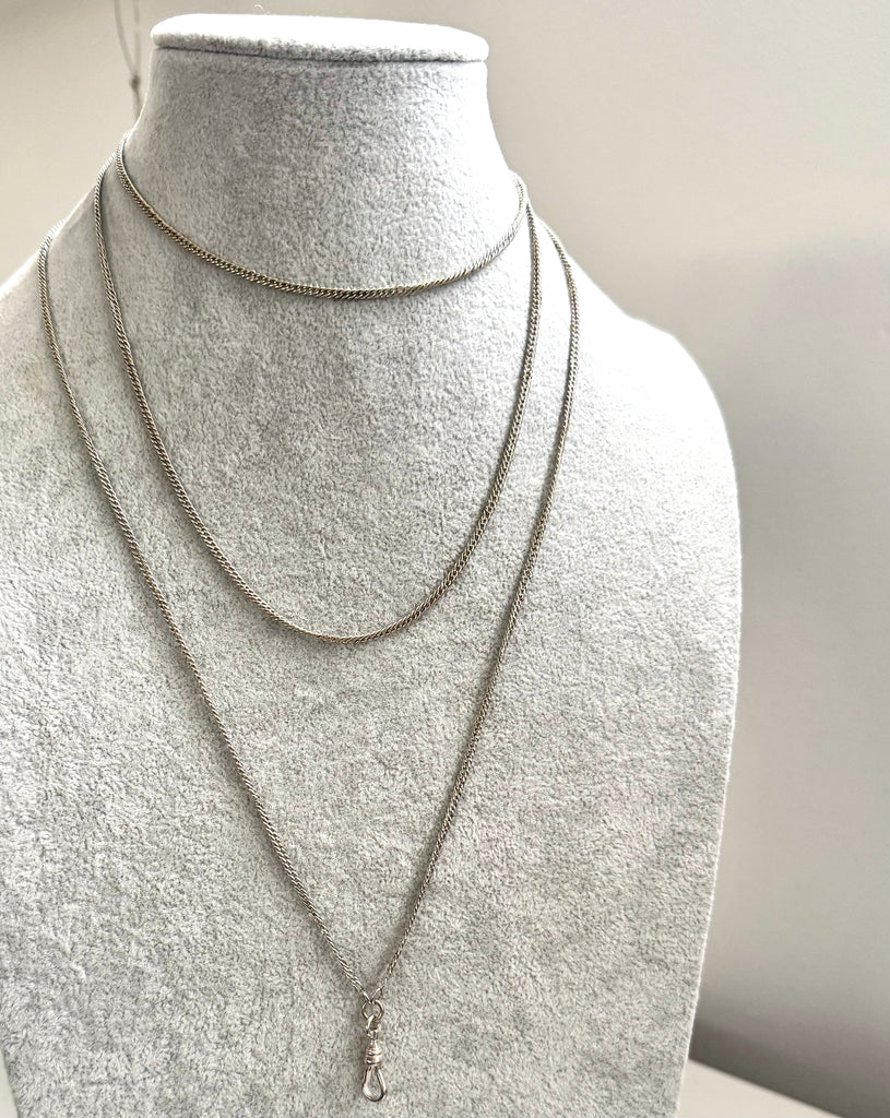 Antique silver guard chain necklace on a grey mannequin
