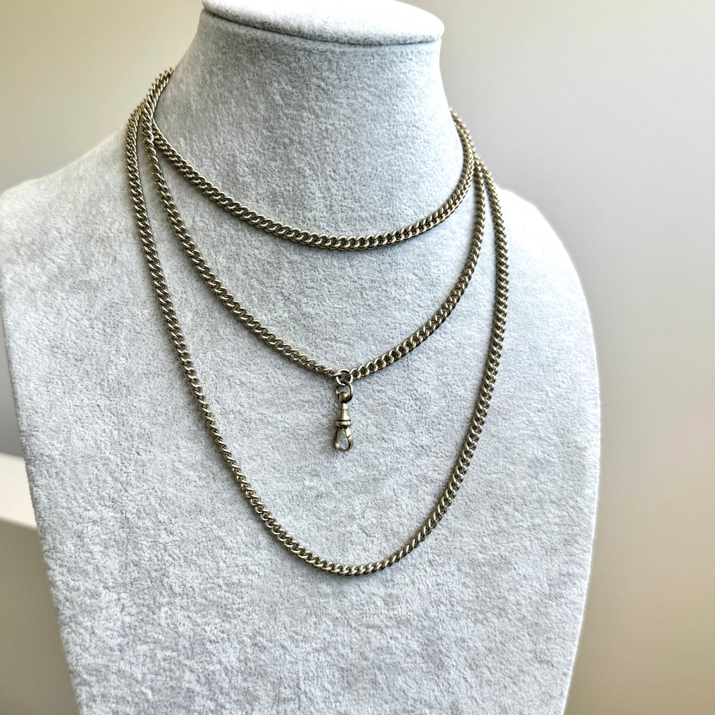 Antique silver plated guard chain on a pale grey mannequin