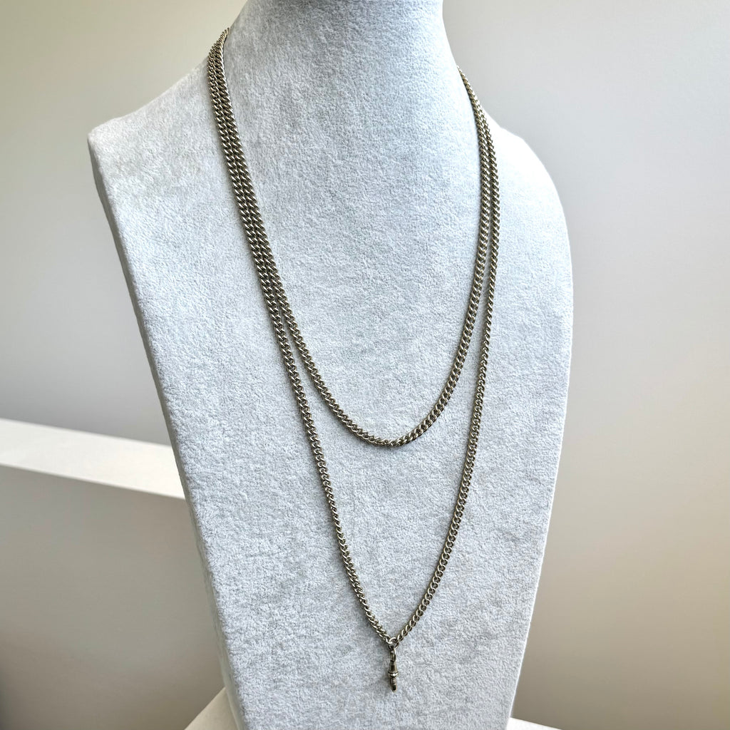 Antique silver plated guard chain on a pale grey mannequin