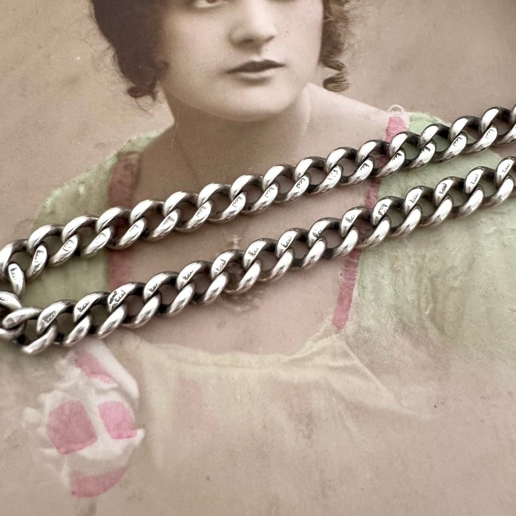 Large silver chain over an old photograph of a woman