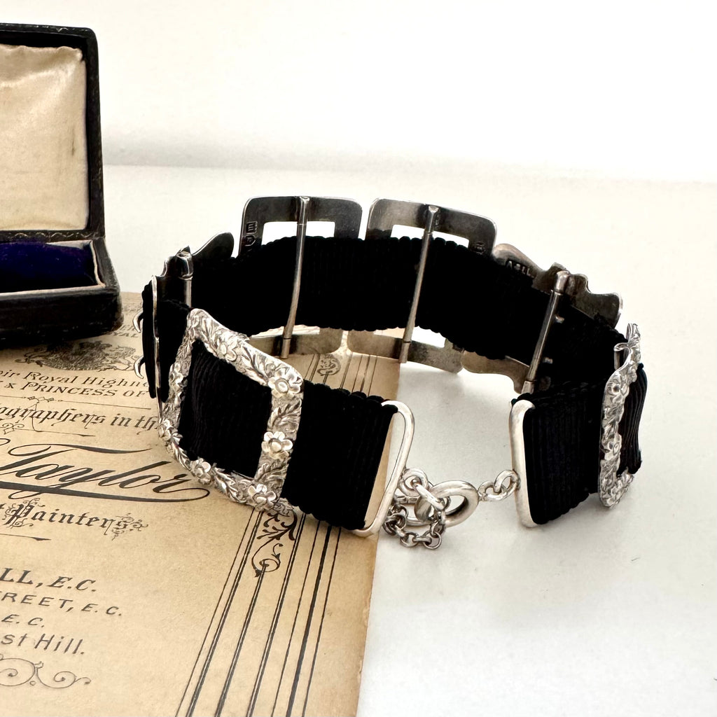 Antique sterling silver buckle bracelet on a vintage box on an old paper background