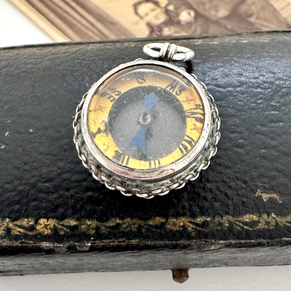 Antique silver compass watch fob on an old jewellery box