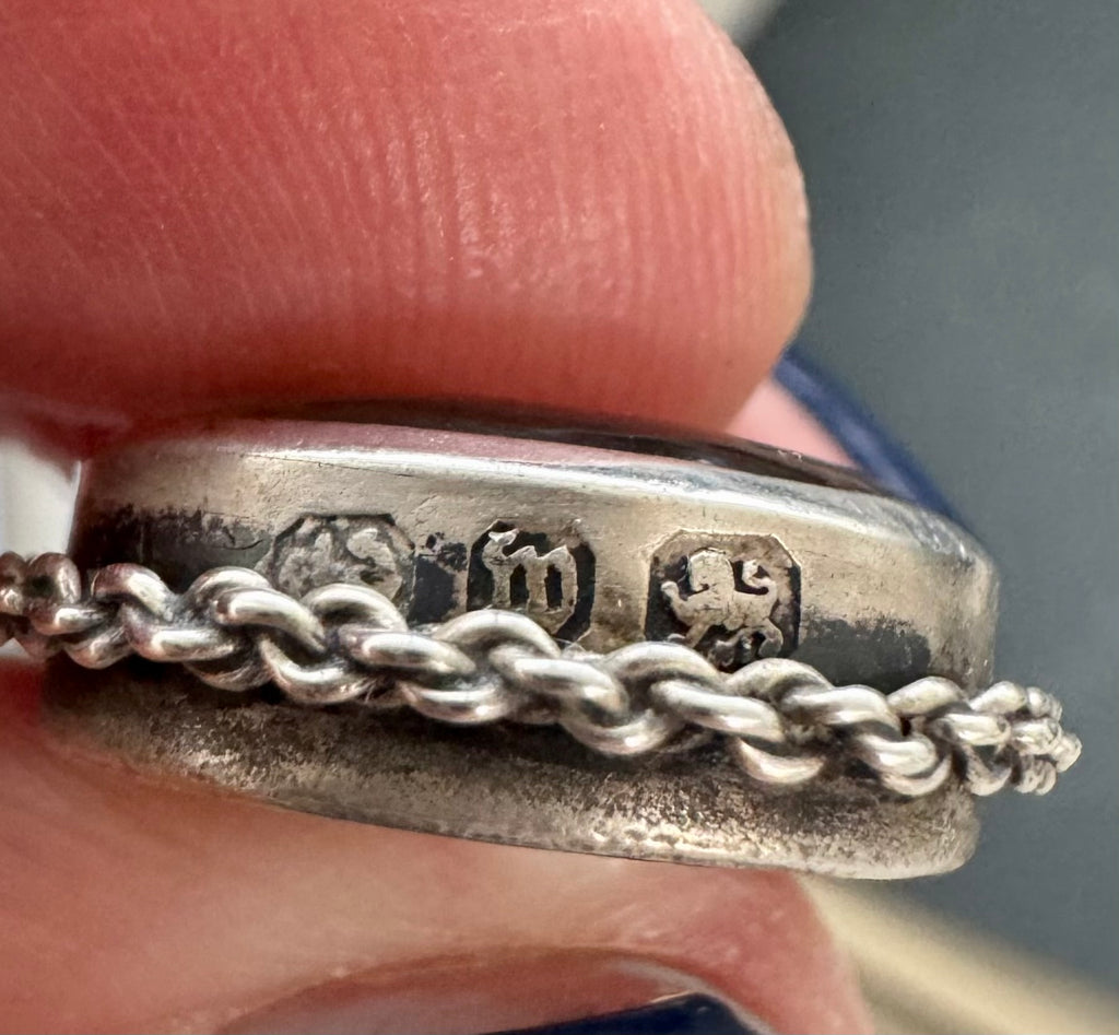 Close up of an antique watch fob showing the hallmarks