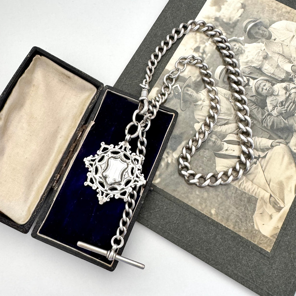 Antique silver albert watch chain and watch fob necklace with an albert clasp on a vintage-style card and jewellery box.